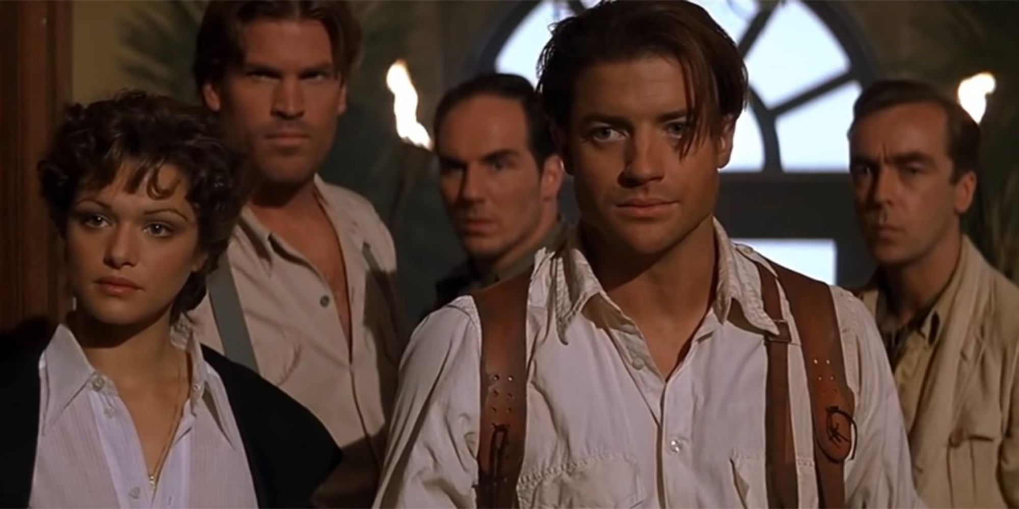 Rachel Weisz and Brendan Fraser looking away with extras behind