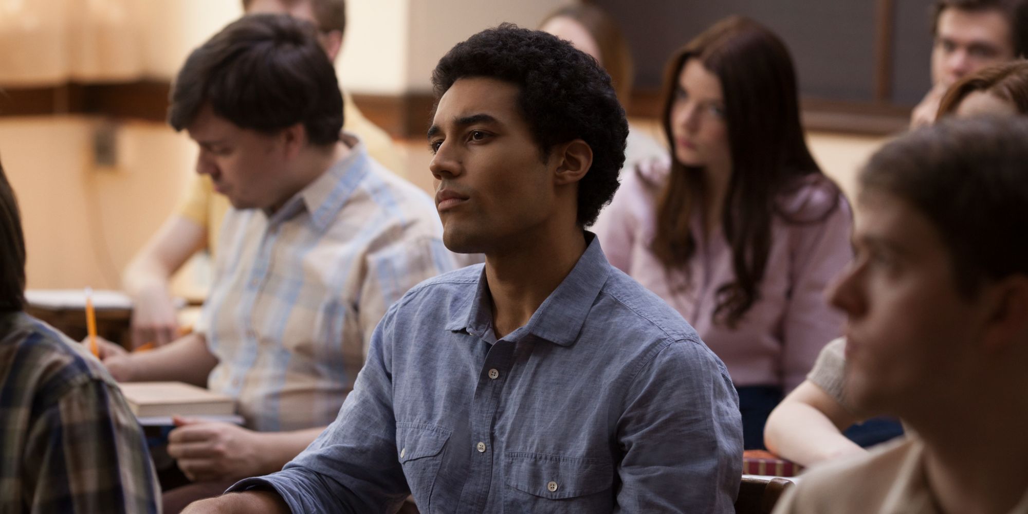 A class full of students, a man sits in the center.