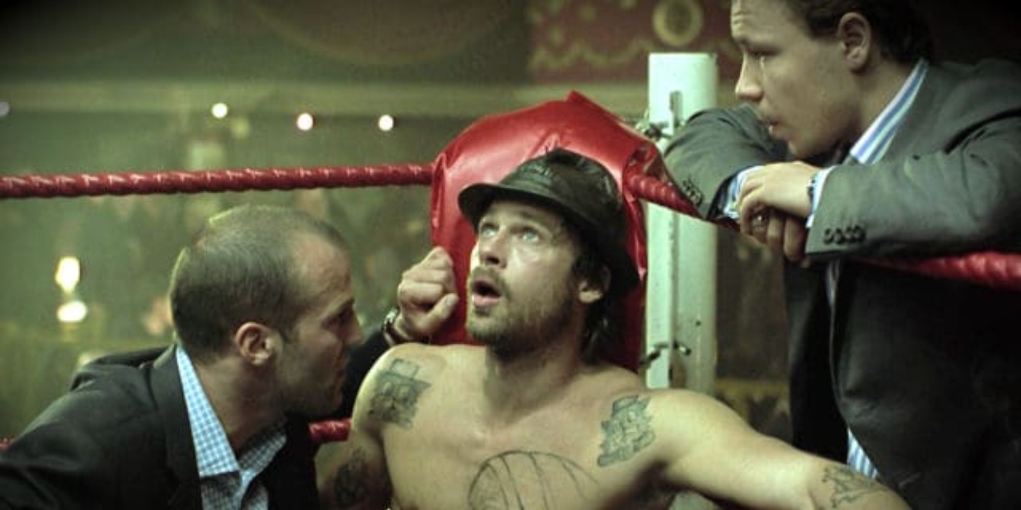 two men consult with a boxer in the corner of the ring