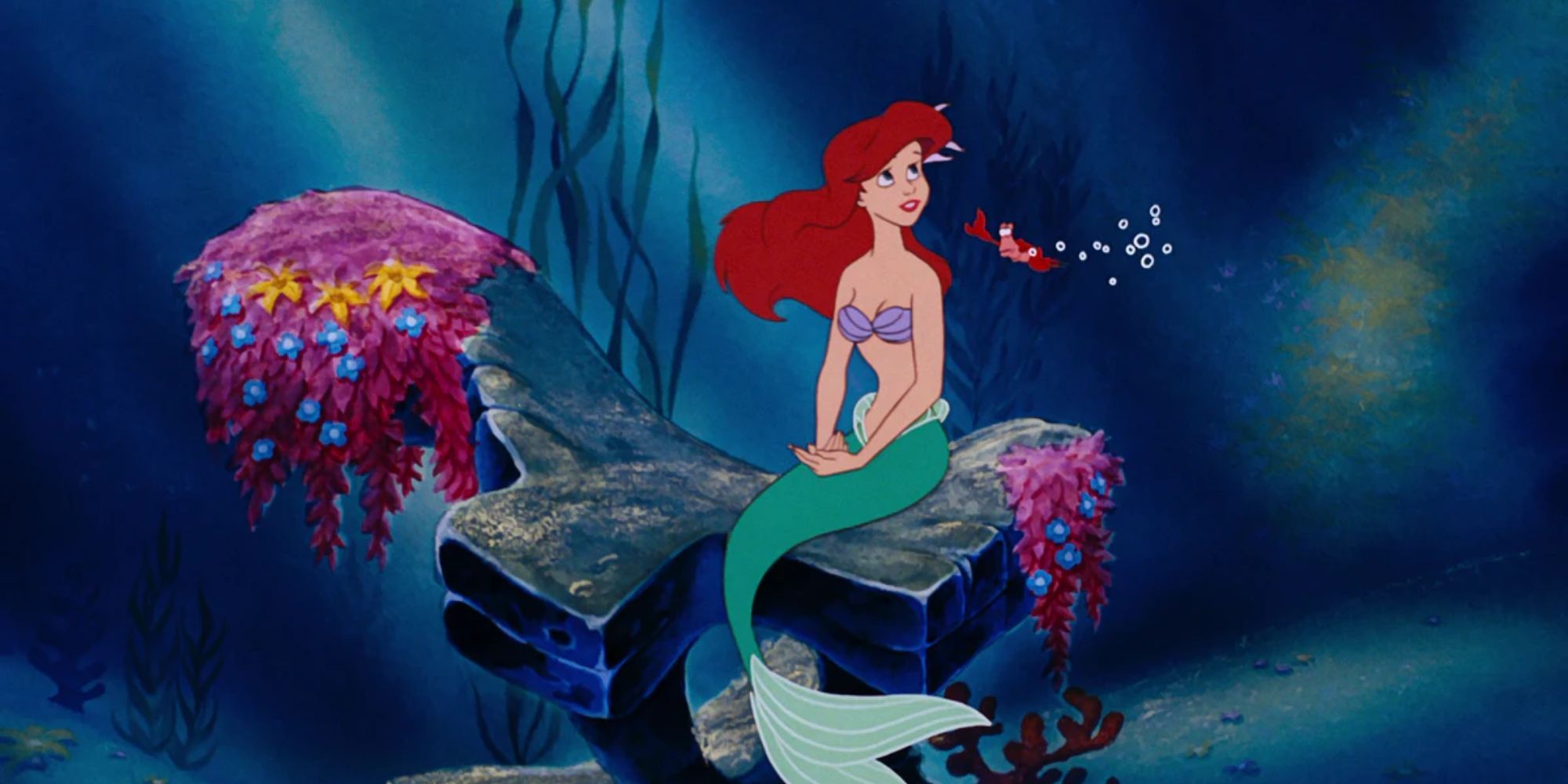 Ariel sits on an underwater rock with his crustacean friend Sebastian.