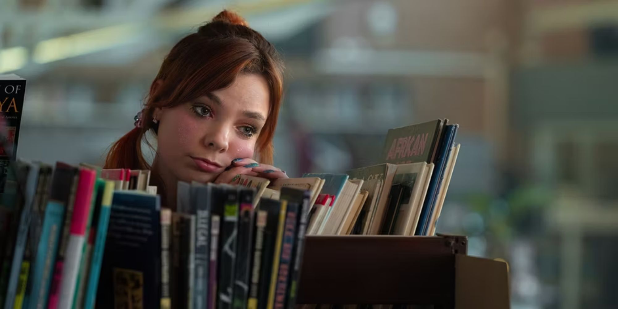 Queenie looks out from behind a bookshelf in the library