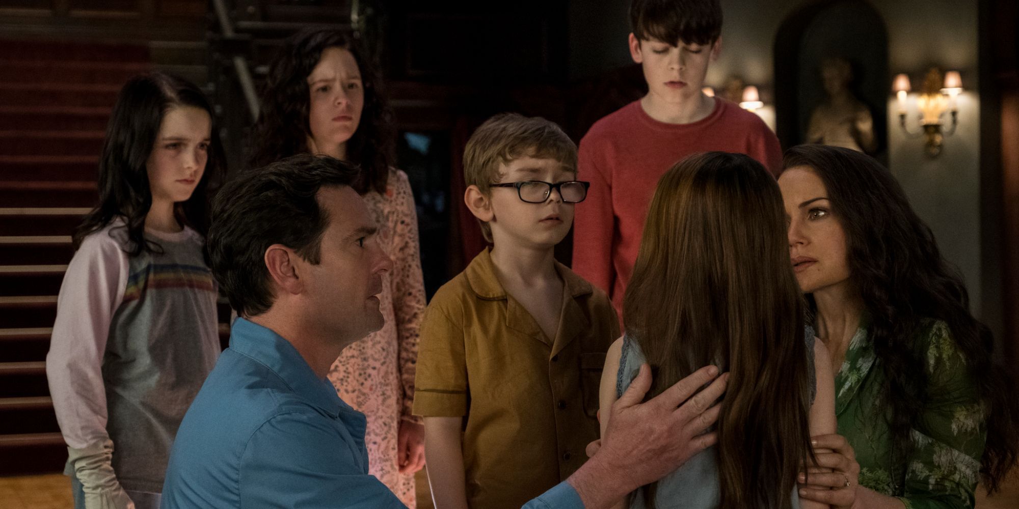 The Crane family surrounding little Nell in the haunted house on the hill