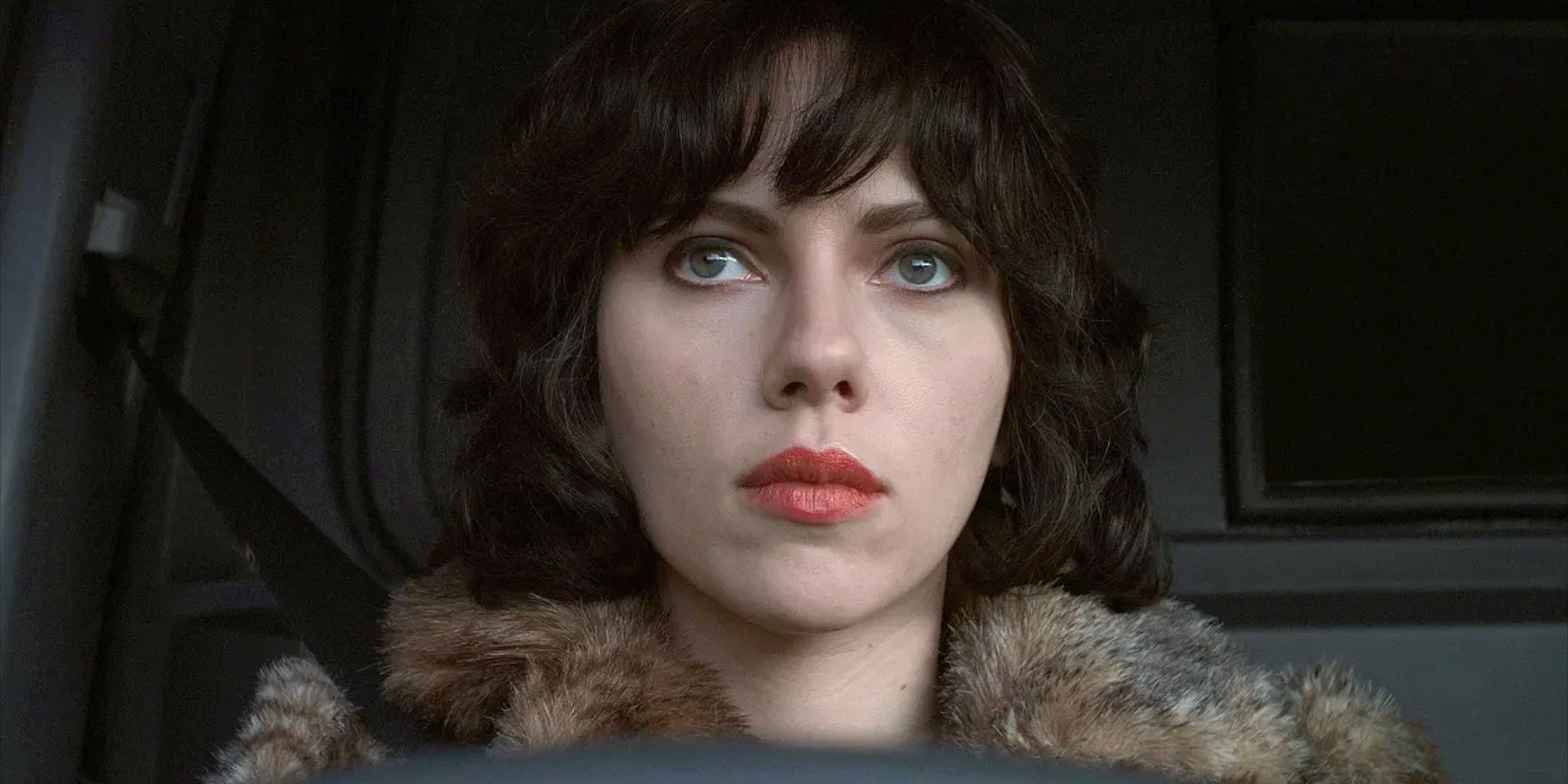 Laura is in the car staring at something off-screen in Under the Skin.