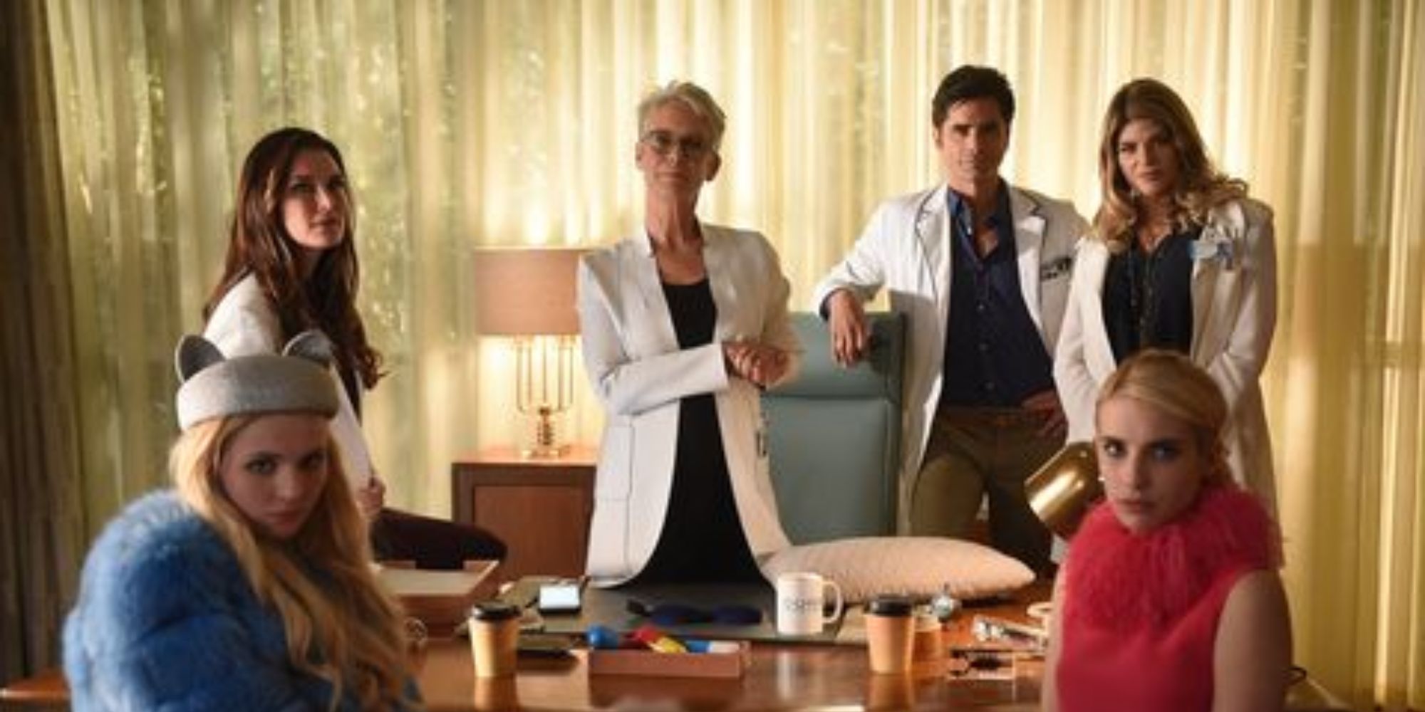 The cast of Scream Queens are looking directly at the camera.