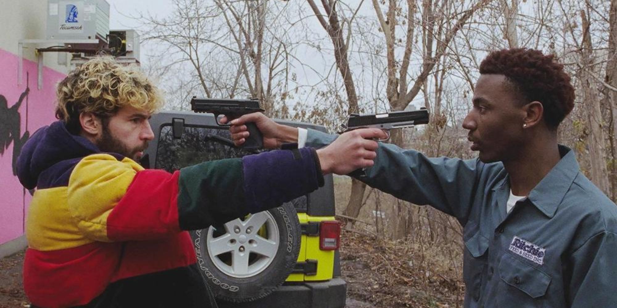 Two men point a gun at each other