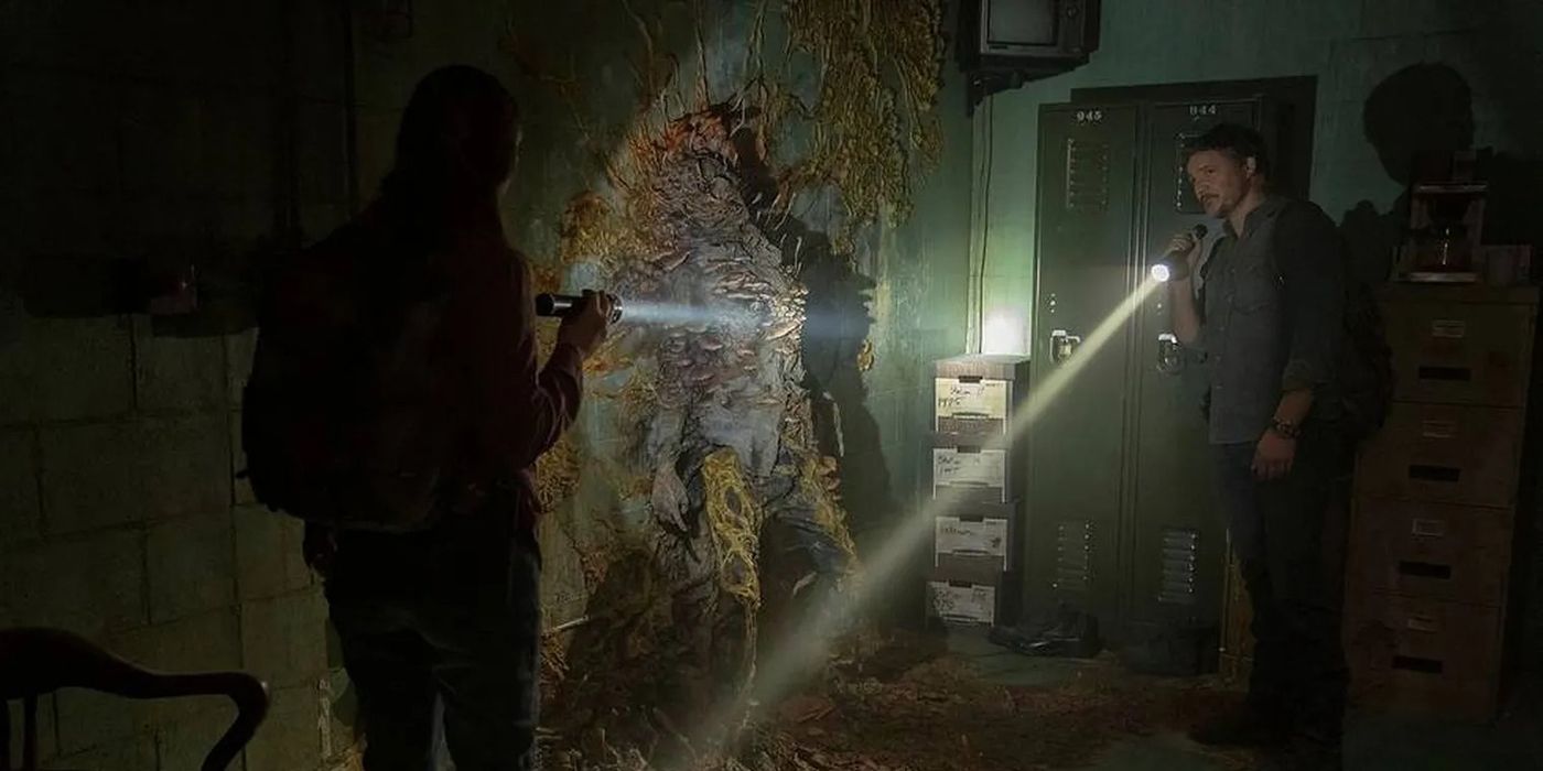 Tess and Joel shine their flashlights on an infected creature stuck to a wall covered in tentacles in The Last of Us.