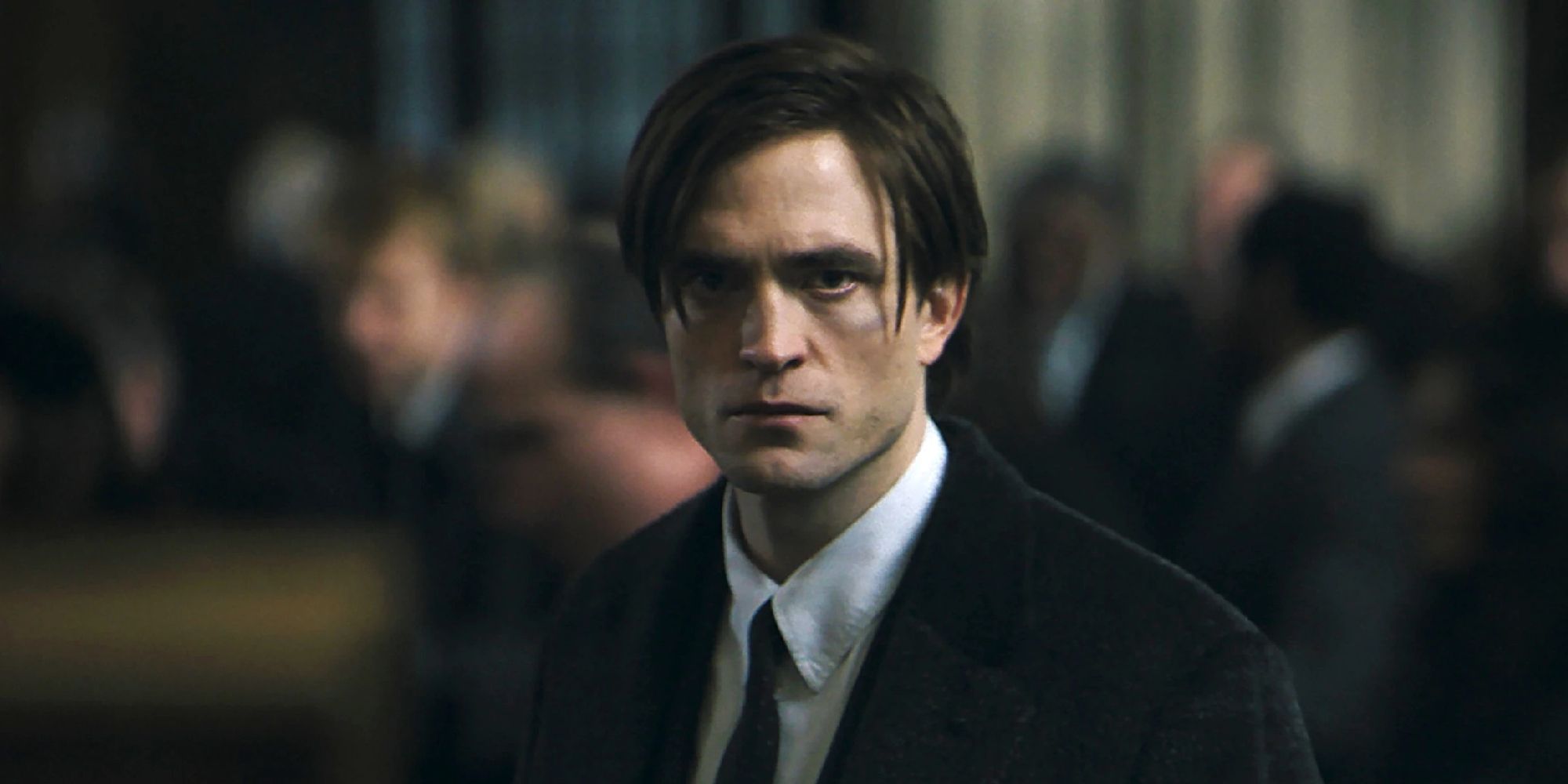 Robert Pattinson looks at the camera as Bruce Wayne in The Batman.