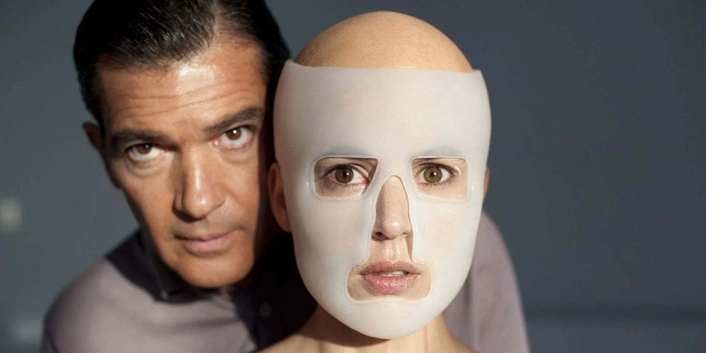 Vera, played by Elena Cruz, wears a translucent plastic mask on her face, while Ledgard, played by Antonio Banderas, stands behind her in The Skin I Live In.
