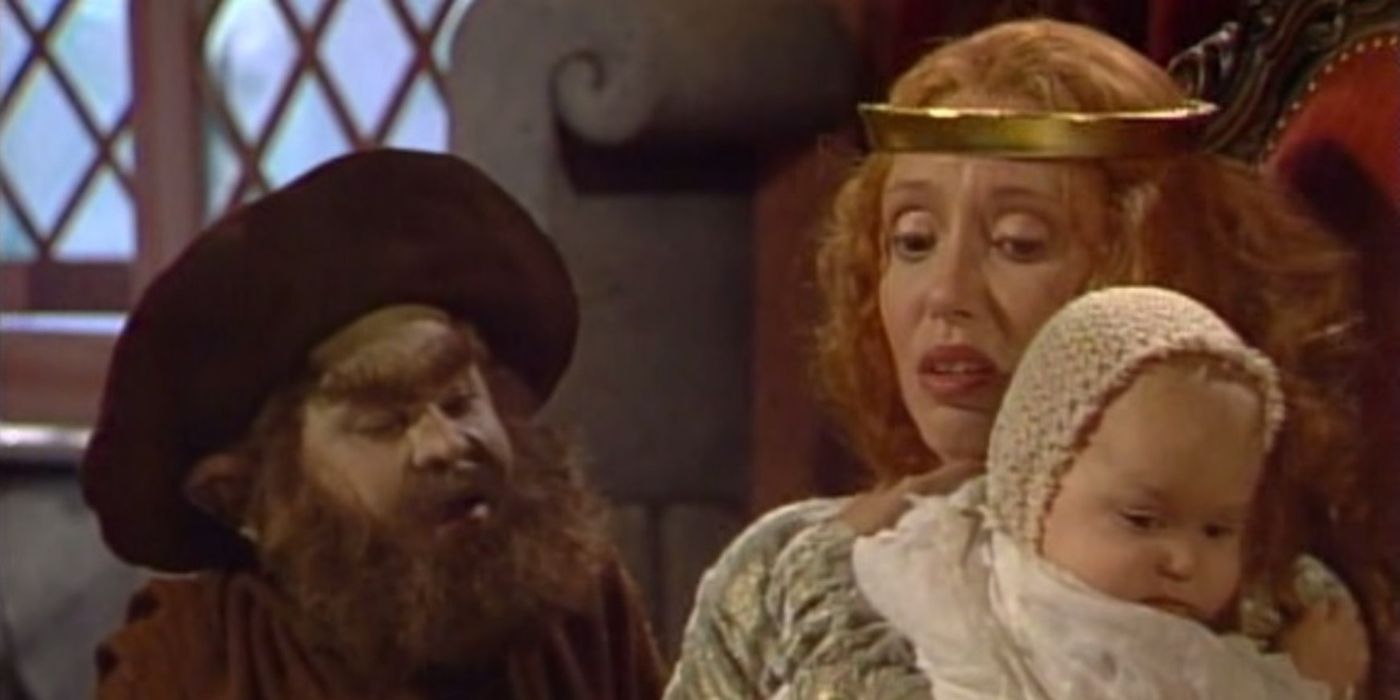 Hervé Villechaise as Rumplestiltskin with Shelley Duvall as the miller's daughter holding a child in the Fairy Tale Theatre.