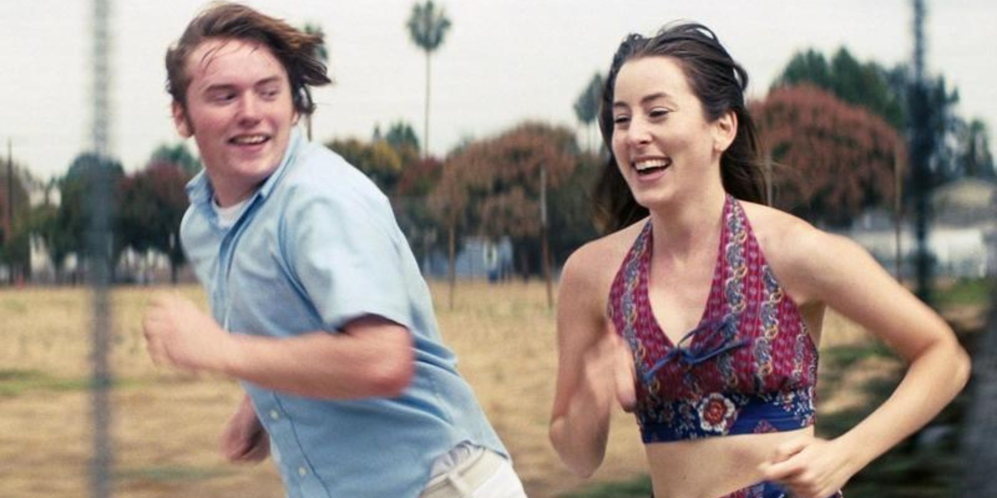 Gary and Alana run through the streets in Licorice Pizza.