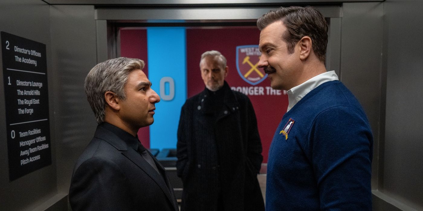 Jason Sudeikis as Ted Lasso and Nick Mohammed as Nate talk to each other before a match in the third season of Ted Lasso.