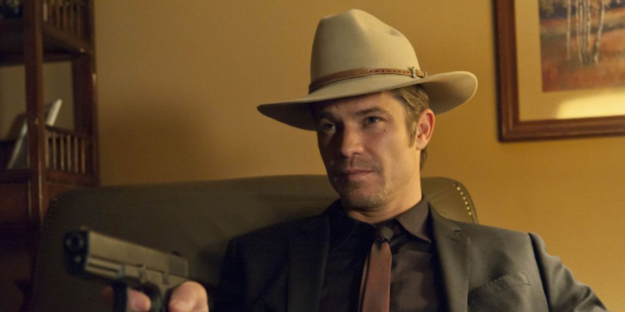 Timothy Olyphant points a gun at someone in Justified