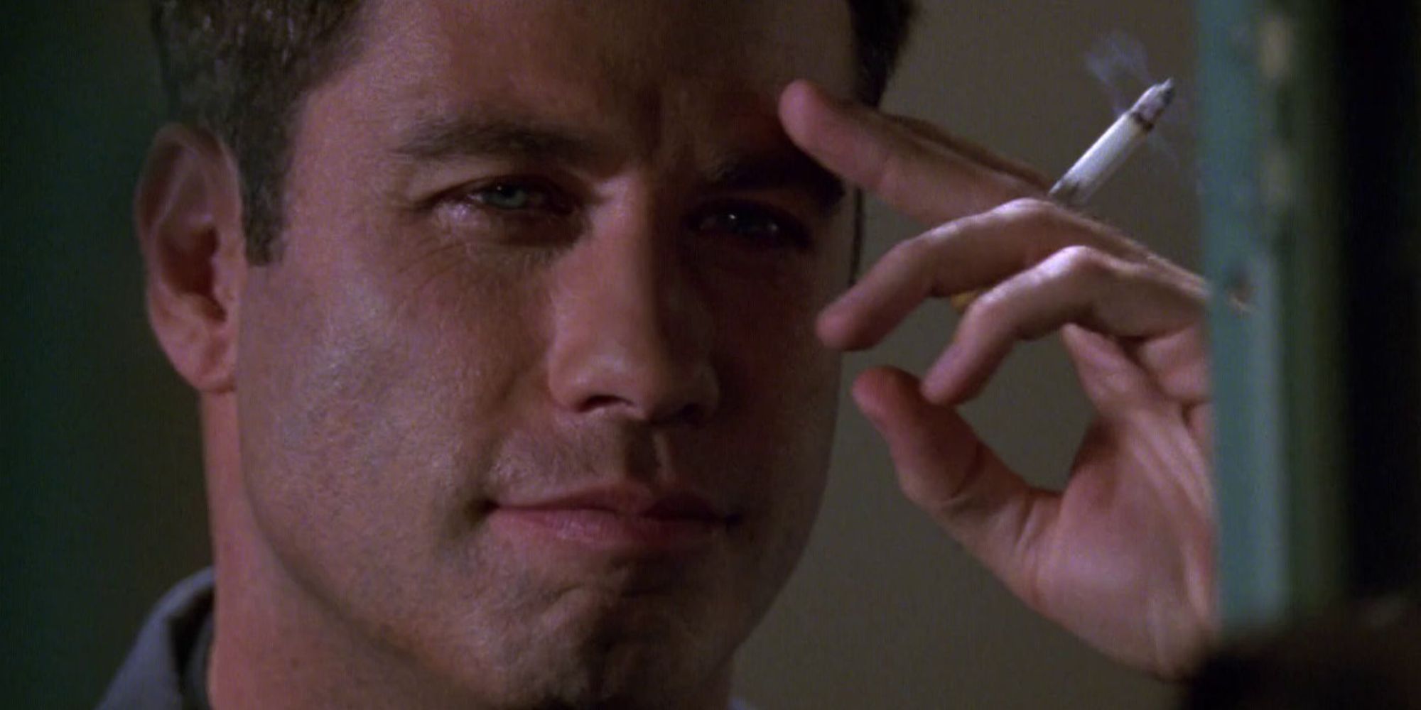 John Travolta holds a lit cigarette in the movie Broken Arrow.